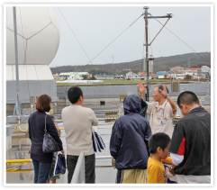 ●施設見学ツアー: センター屋上に設置された気象観測機器の説明を聞く来場者