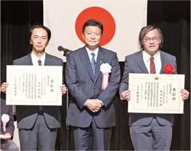 中央は新藤義孝総務大臣、左が田中正人、右が木村和宏