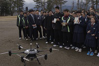 配送された本を手にした中学生とドローン